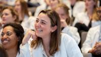 Female medical student smiling in group of students.